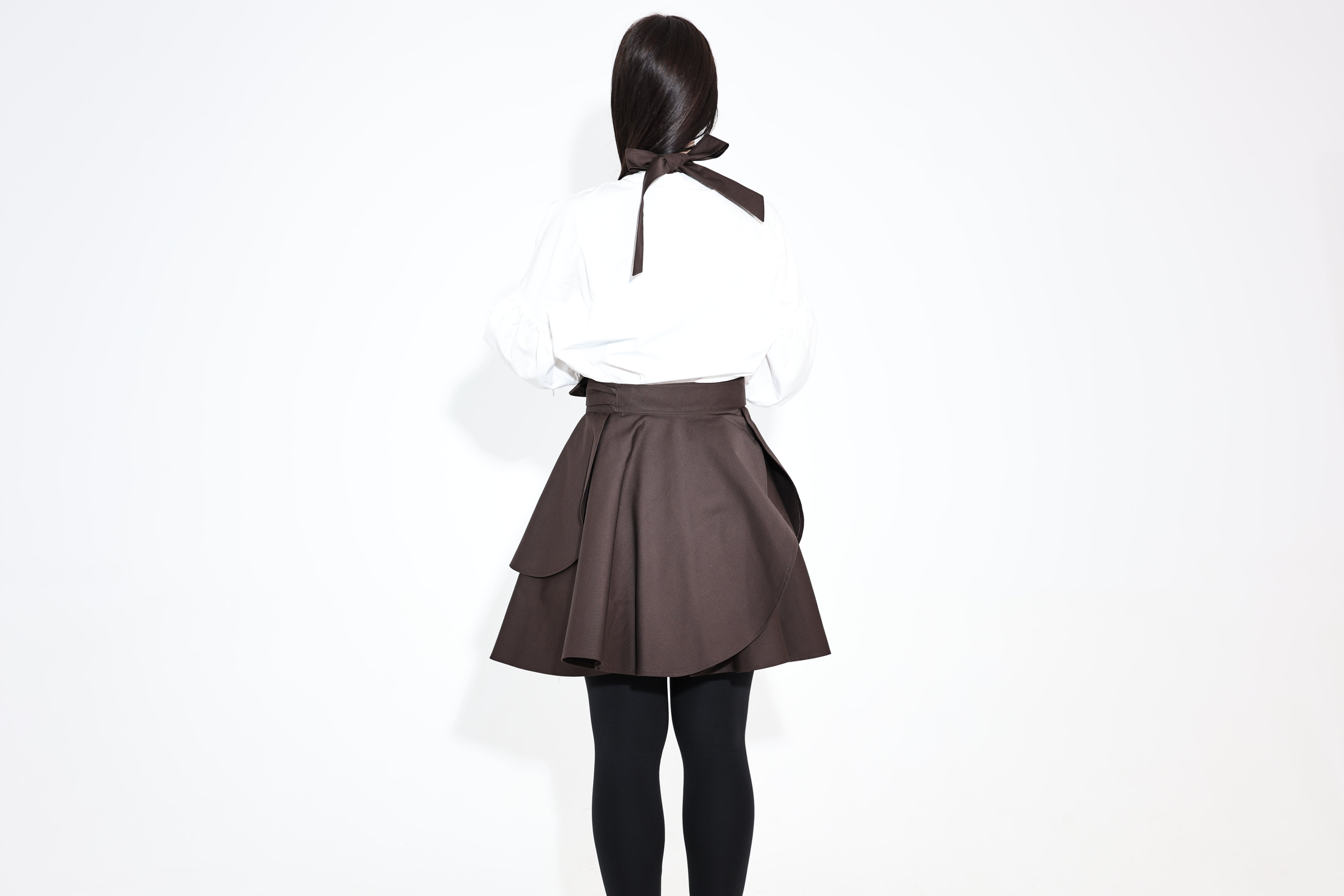 Back view of the dark brown Daisy apron with a ribbon tie at the neck
