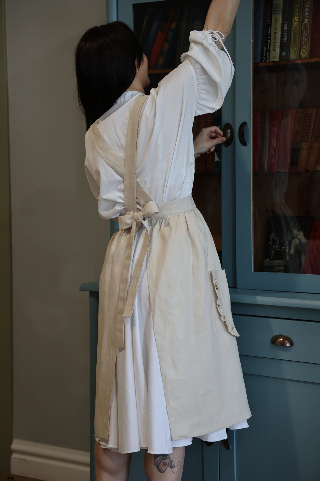 Back view of the sand crossback apron with straps tied in a bow