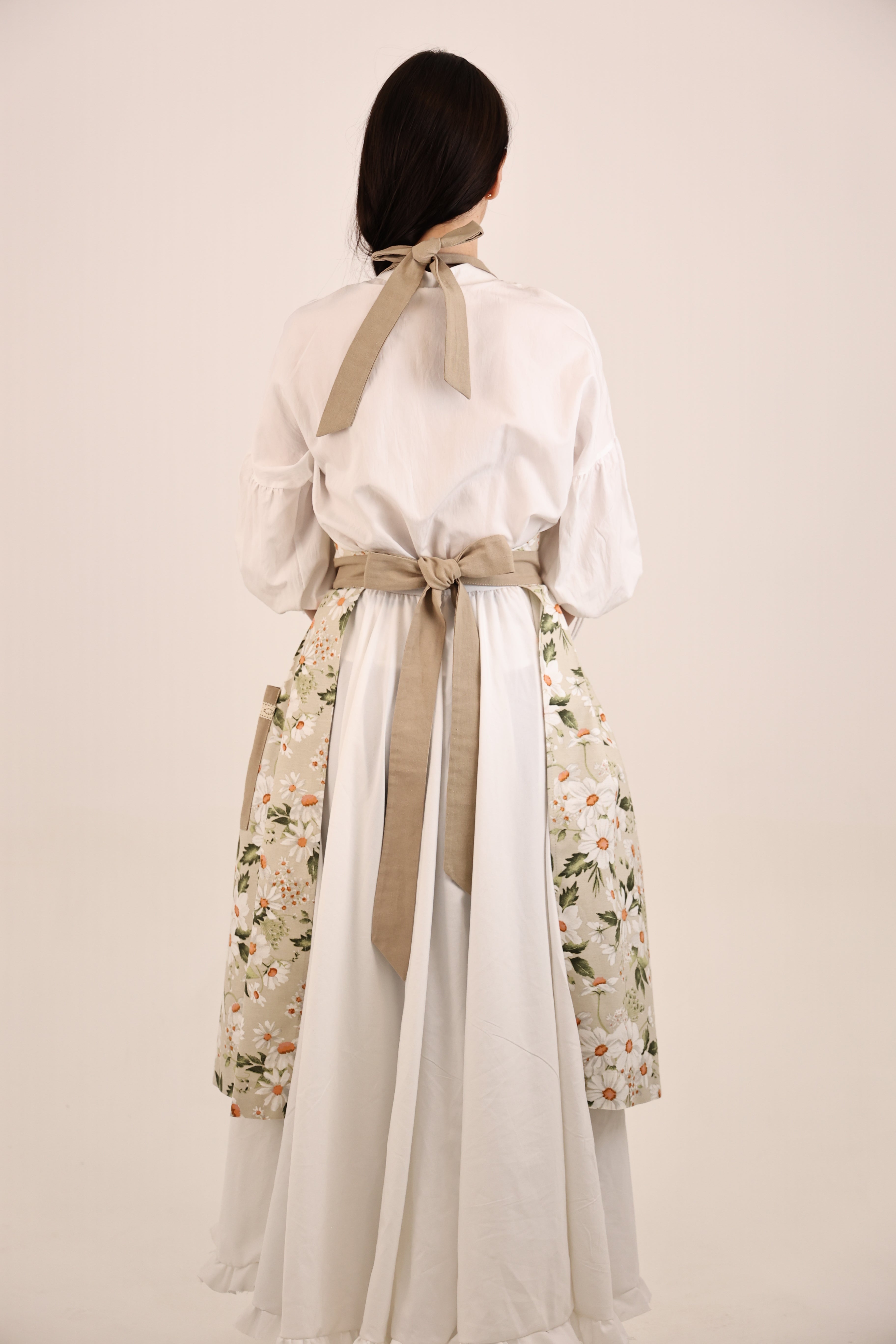 Traditional Korean hanbok with floral skirt and white top on a plain background