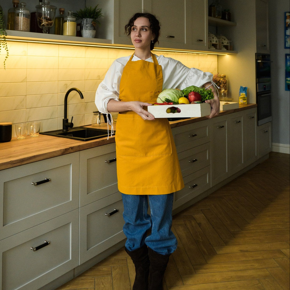 Full-length view of the mustard cotton bib apron with a wide front pocket