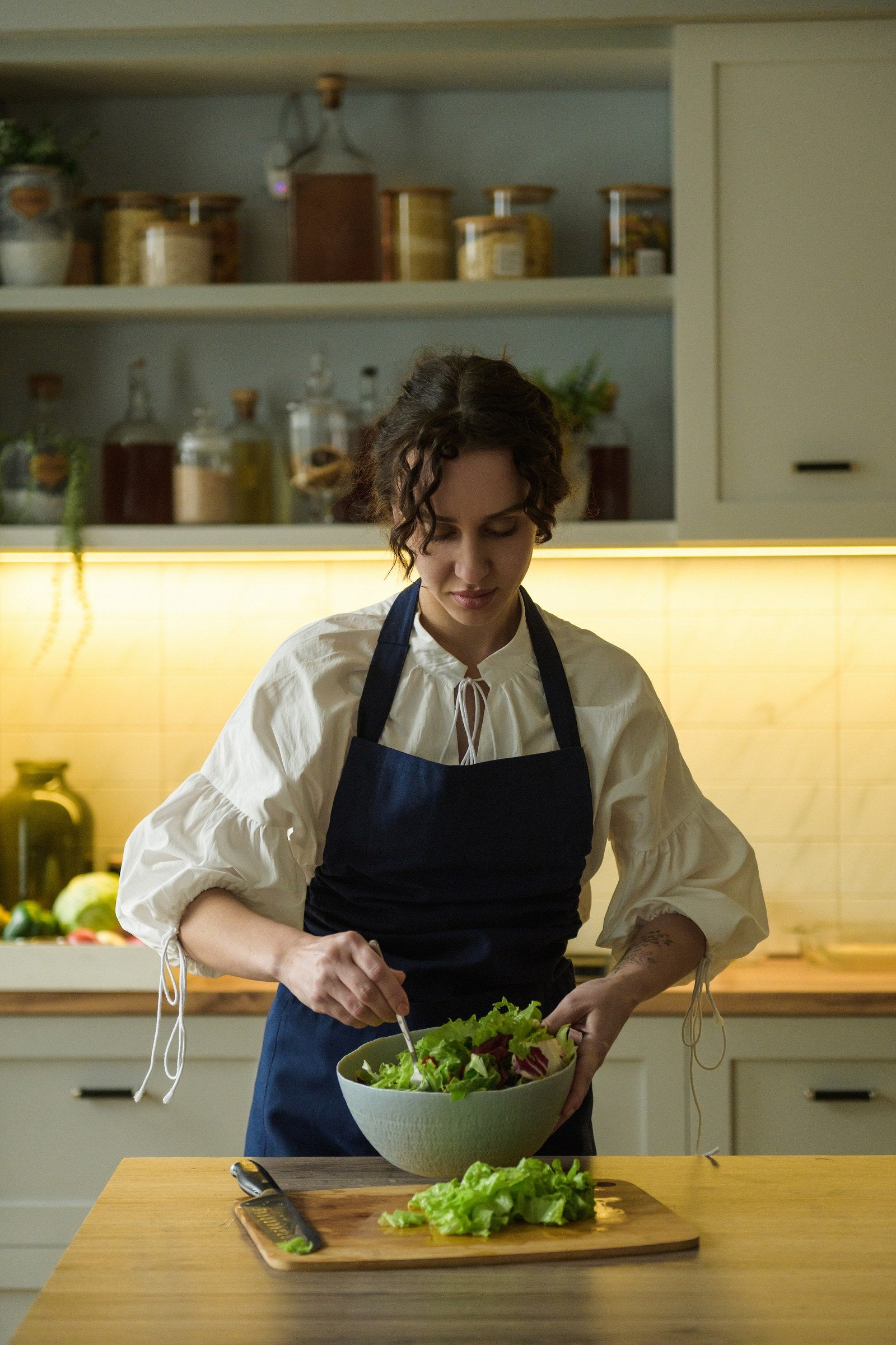 Navy blue bib apron with an adjustable neck strap and long waist ties