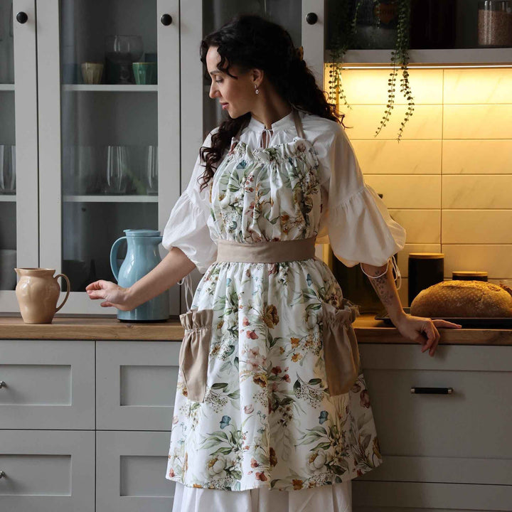 Woman in a floral apron standing in a kitchen