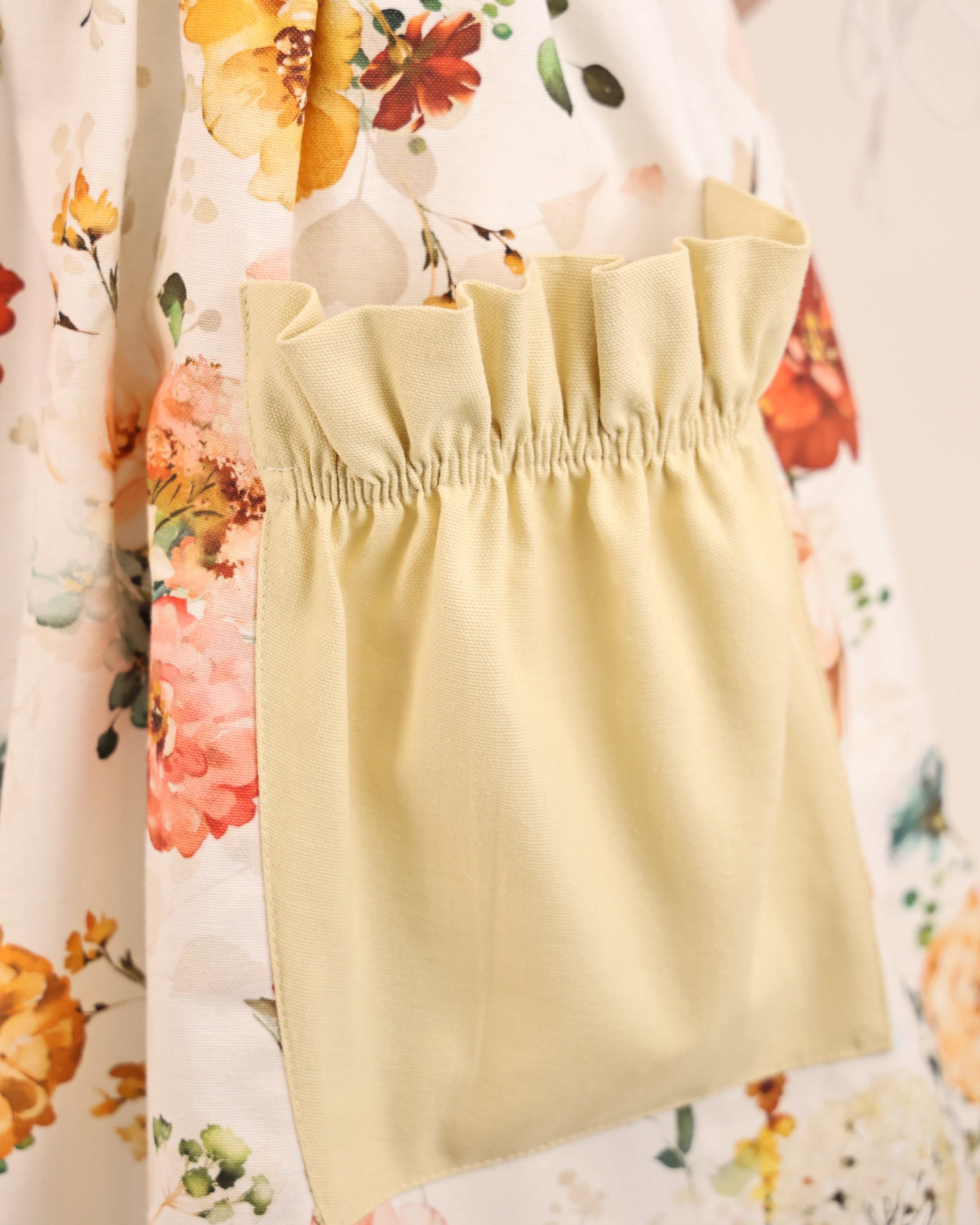 Yellow apron over a floral dress with a blurred background