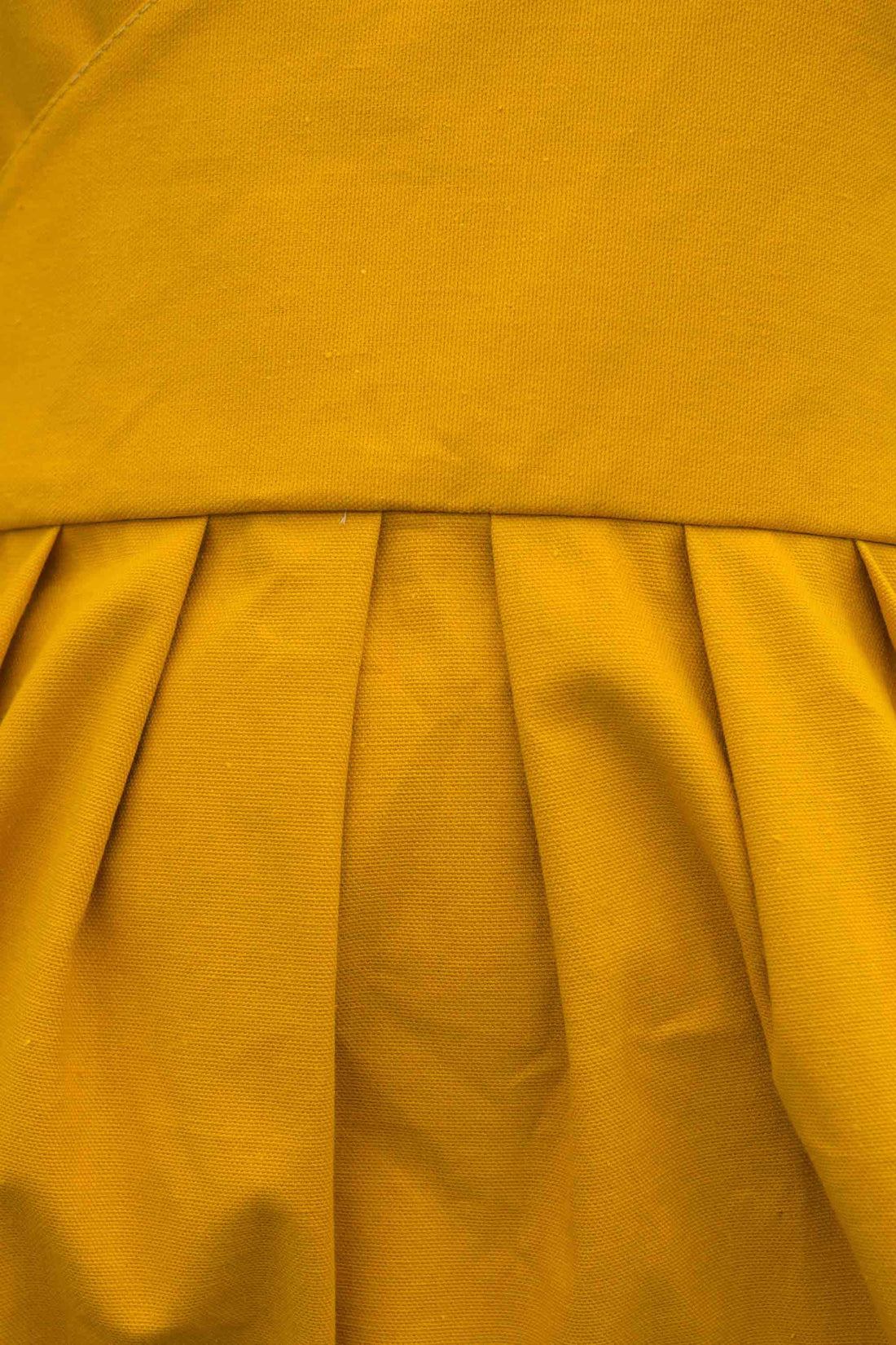Close-up of a mustard yellow fabric with pleated texture