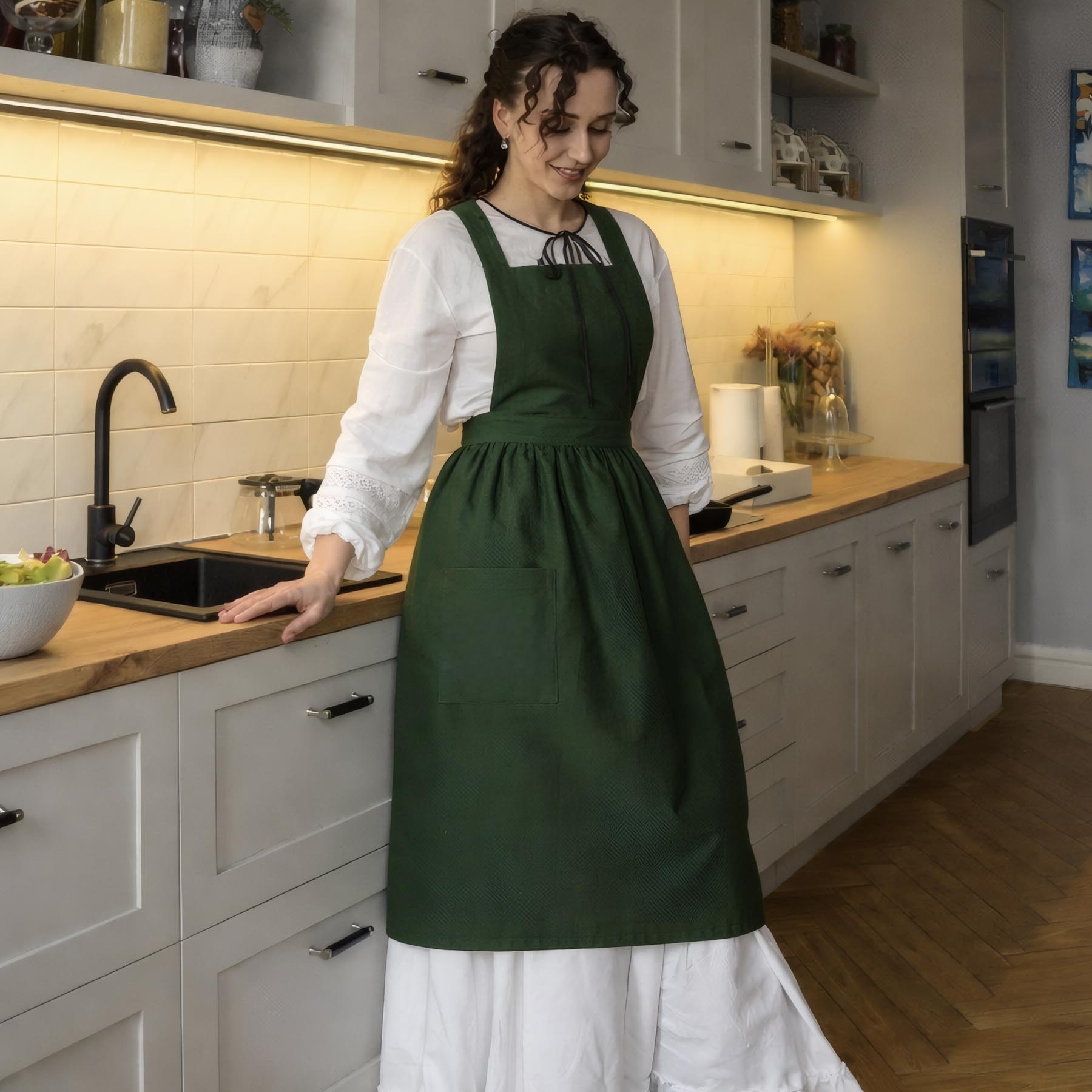 Woman in a green apron standing in a kitchen