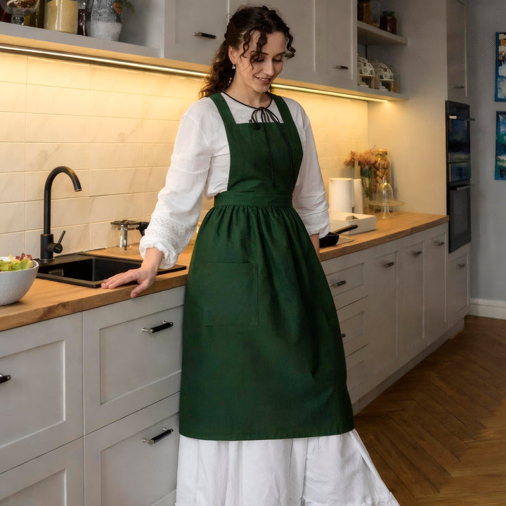 Woman in a green apron standing in a kitchen