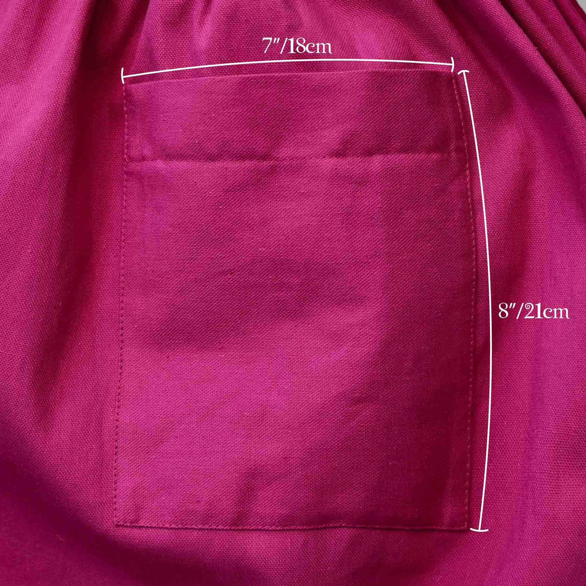 Close-up of a magenta fabric pocket with measurements indicated.