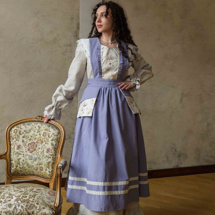 Woman in a vintage-style dress holding an ornate chair against a textured wall.