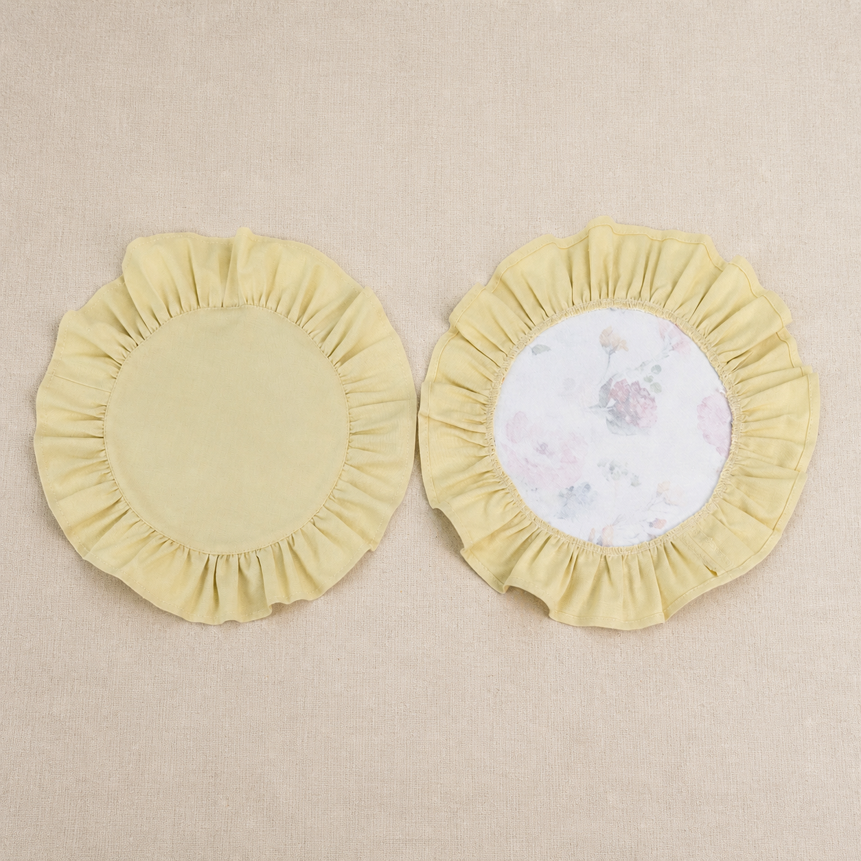 Two round butter yellow ruffle placemats, one plain and one with a white centre panel