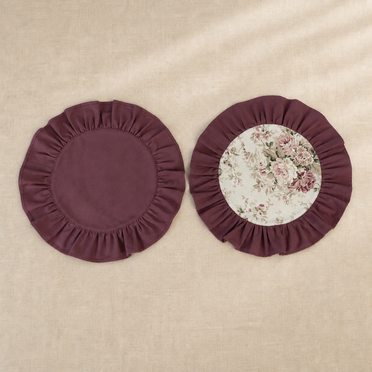 Two round deep burgundy ruffle placemats, one plain and one with a vintage rose print centre