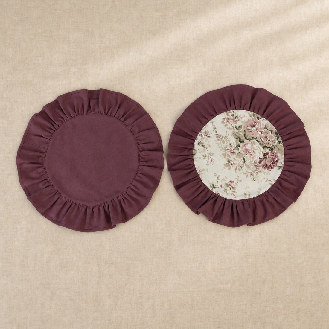 Two round deep burgundy ruffle placemats, one plain and one with a vintage rose print centre