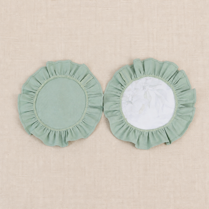 Two round sage green ruffle placemats, one plain and one with a white centre panel