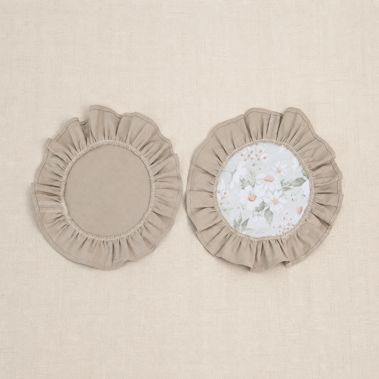 Two round taupe beige ruffle placemats, one plain and one with a white centre panel