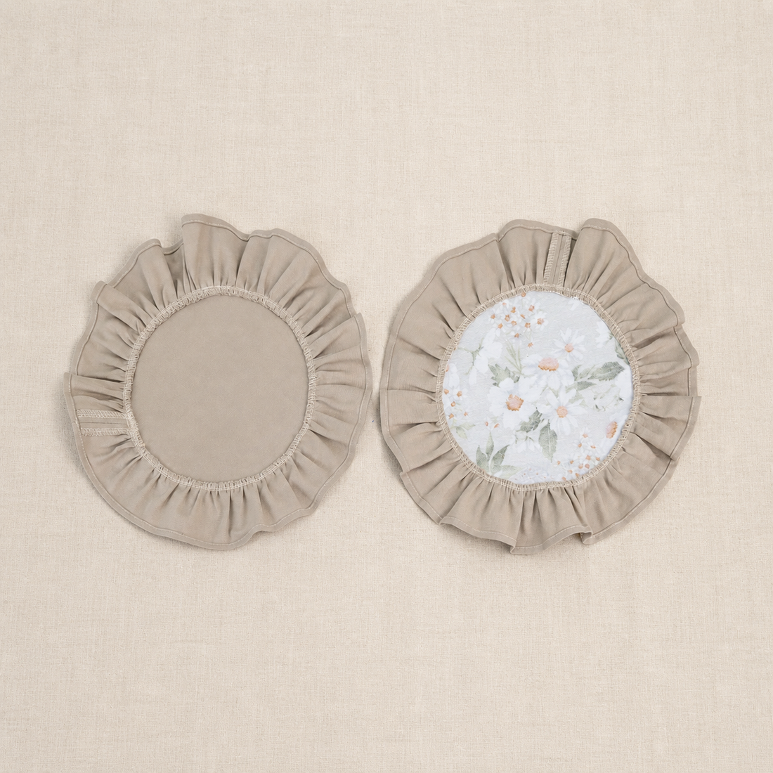 Two round taupe beige ruffle placemats, one plain and one with a white centre panel