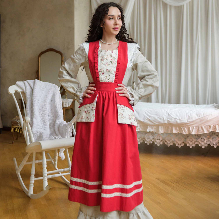 Woman in a red and white dress standing in a vintage room with wooden floor and white furniture.